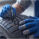 mechanic checking tire tread depth and wear 2048x999 1